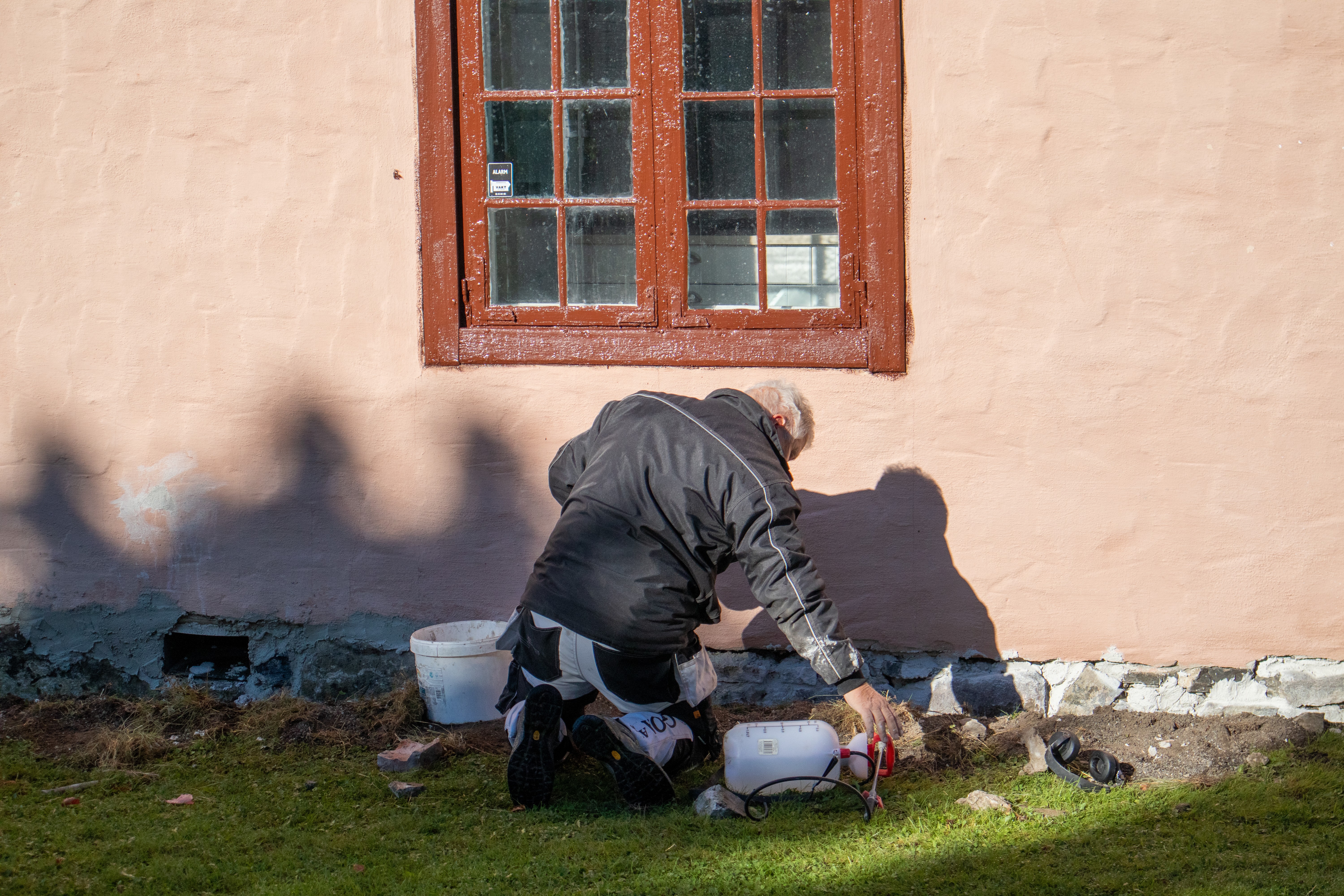 Bildet viser en som maler vegg på Riddergården.