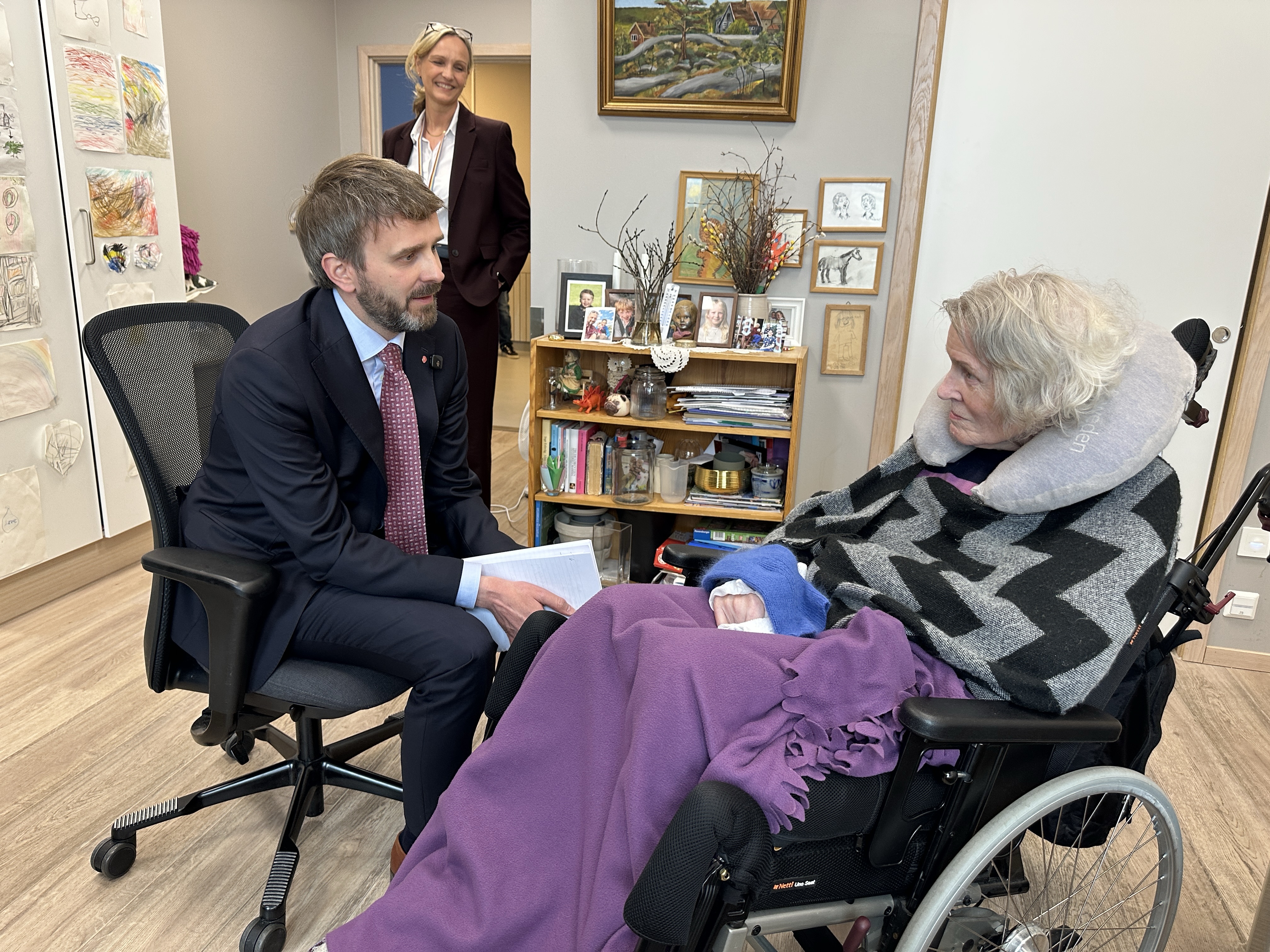 Statsr&aring;den er inne hos en av beboerne p&aring; Heradsbygda. De snakker sammen.