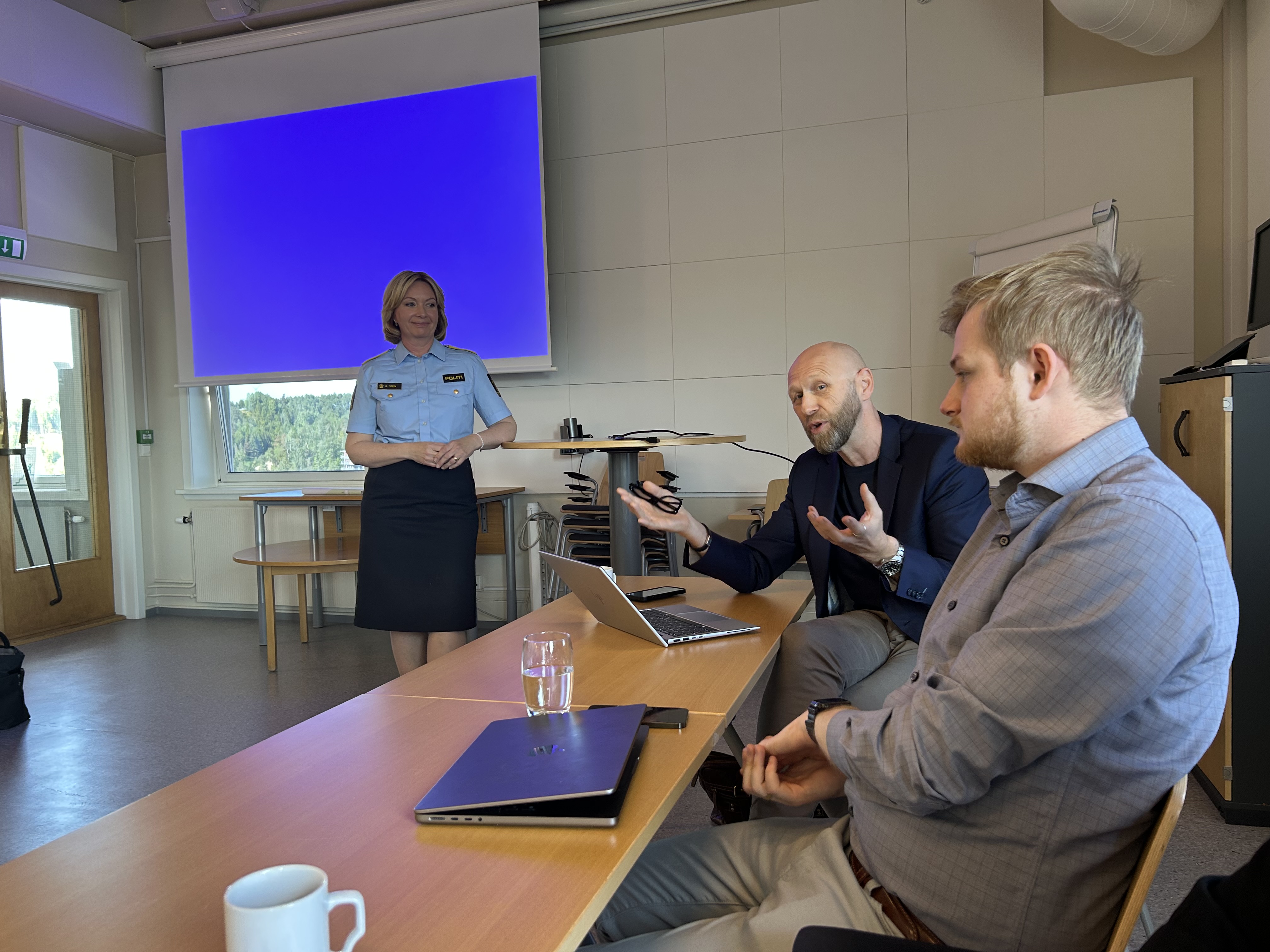 Bildet viser kommunedirektøren i Ringerike som snakker. Bak står politimesteren.