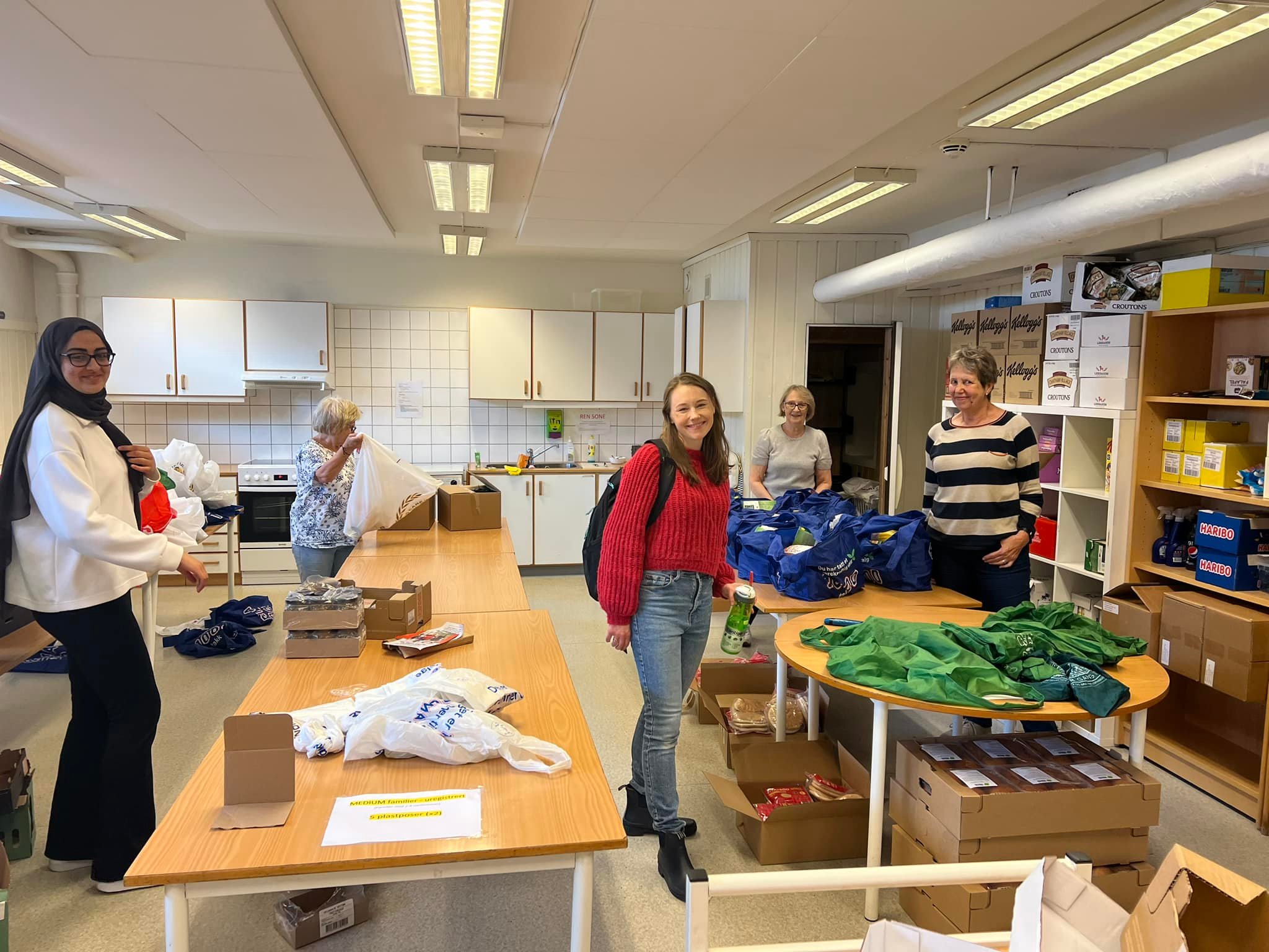 Bildet viser frivillige som skal pakke mat i poser.