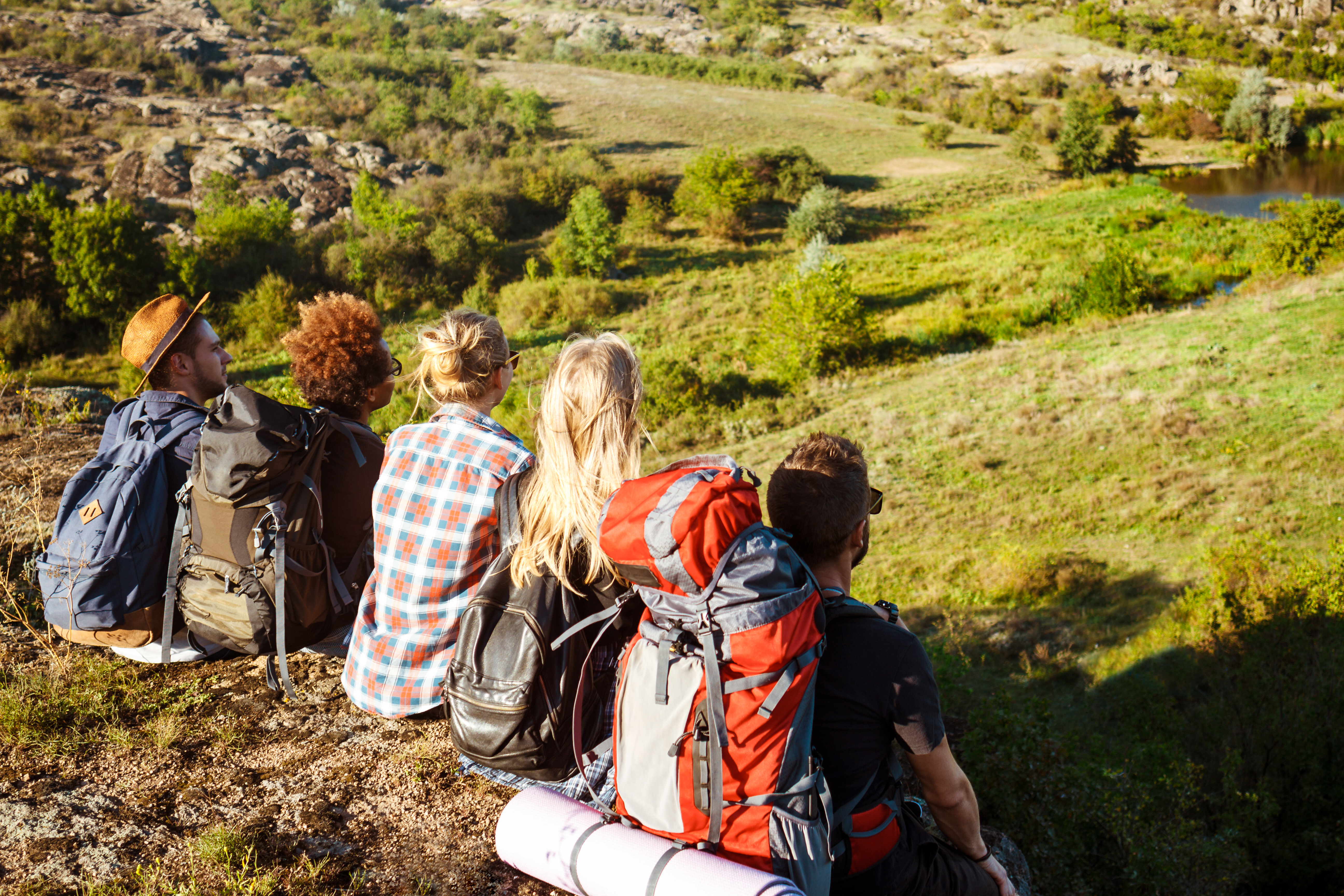 young-friends-travelers-sitting-rock-canyon-enjoying-view.jpg