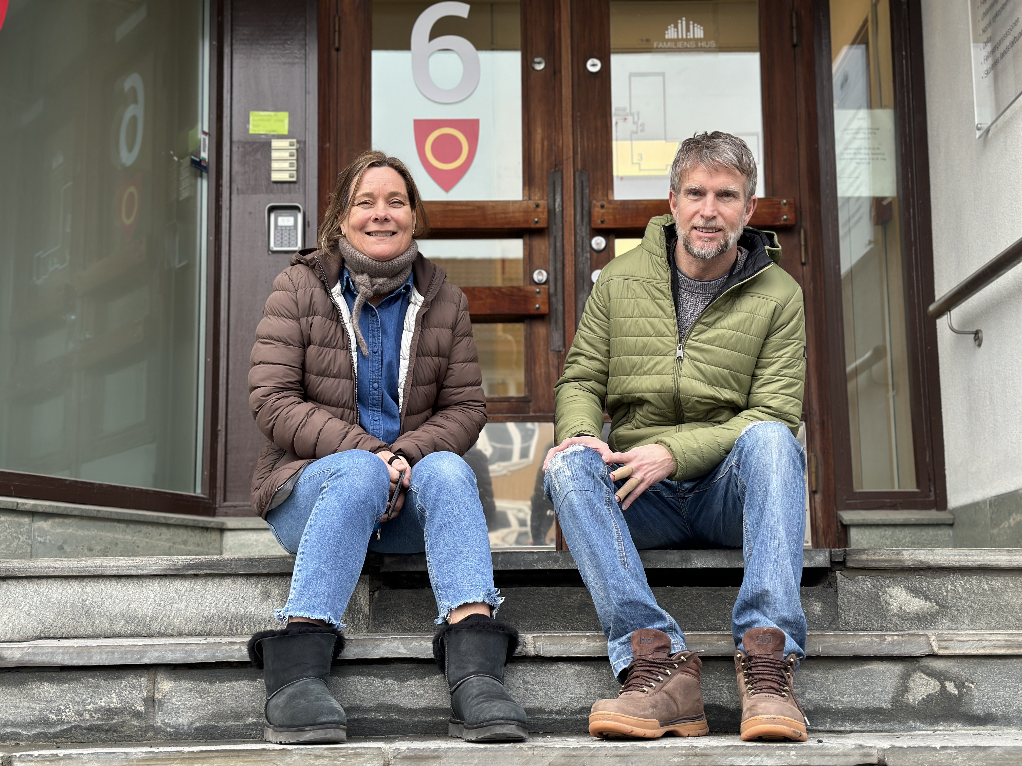 Bildet viser Lena og Rune. De sitter på trappa inn til Ungdomskontakten i Ringerike som holder til i Familiens hus.