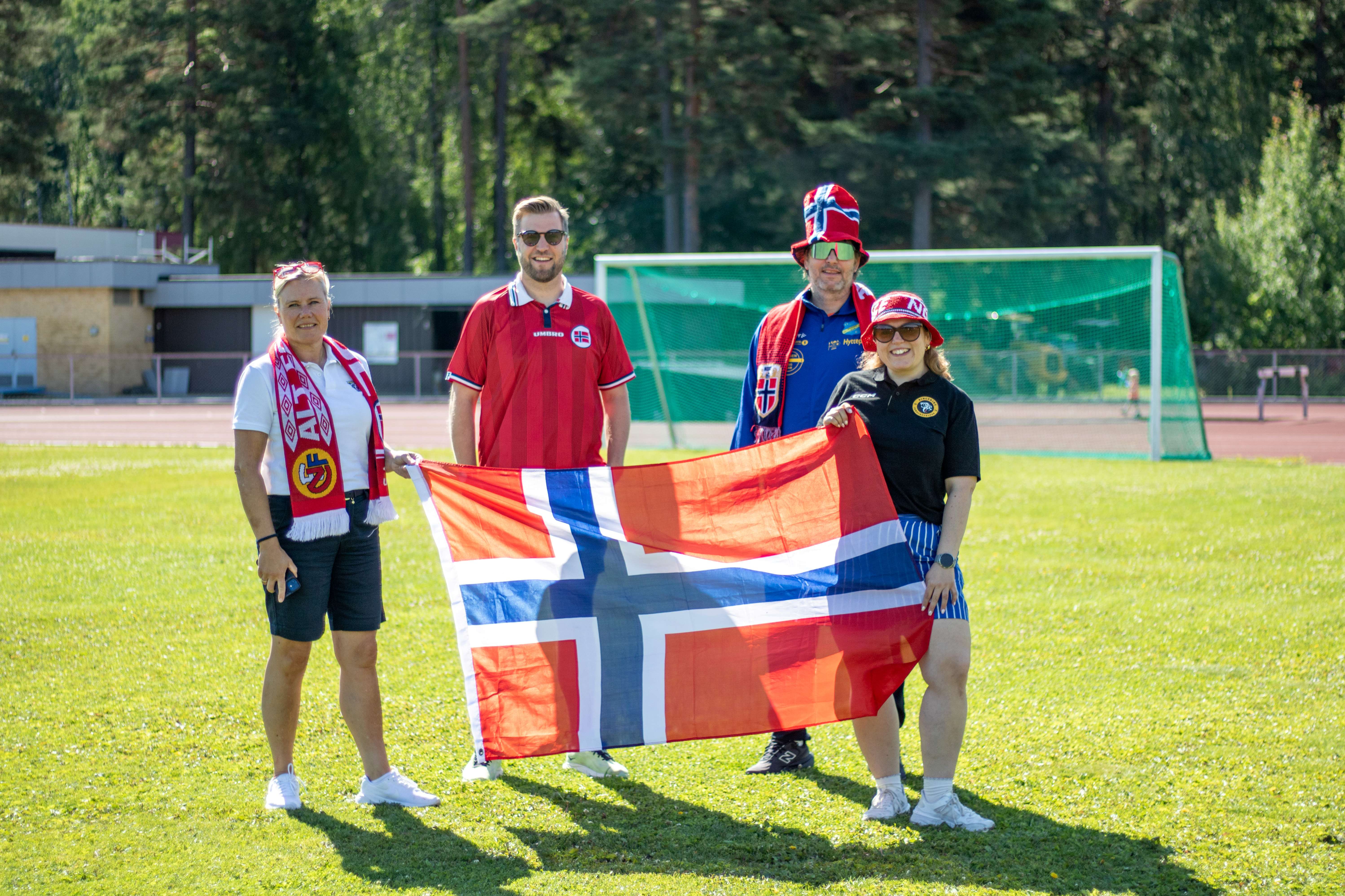 Bildet viser de lokale idrettslagene som arrangerer VM-festen. De er ikledd supporterutstyr og norske flagg.