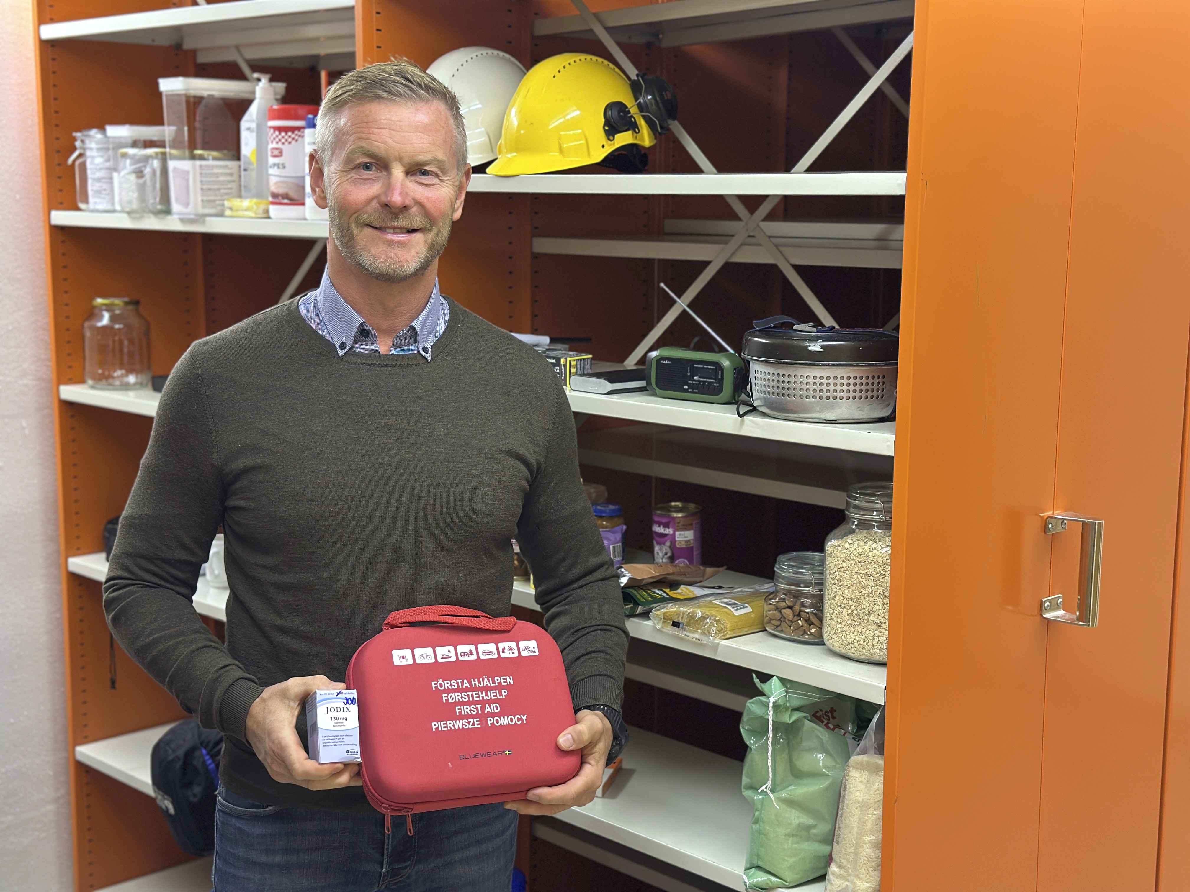 Bildet viser Magnus Nilholm som holder fram et førstehjelpsskrin.