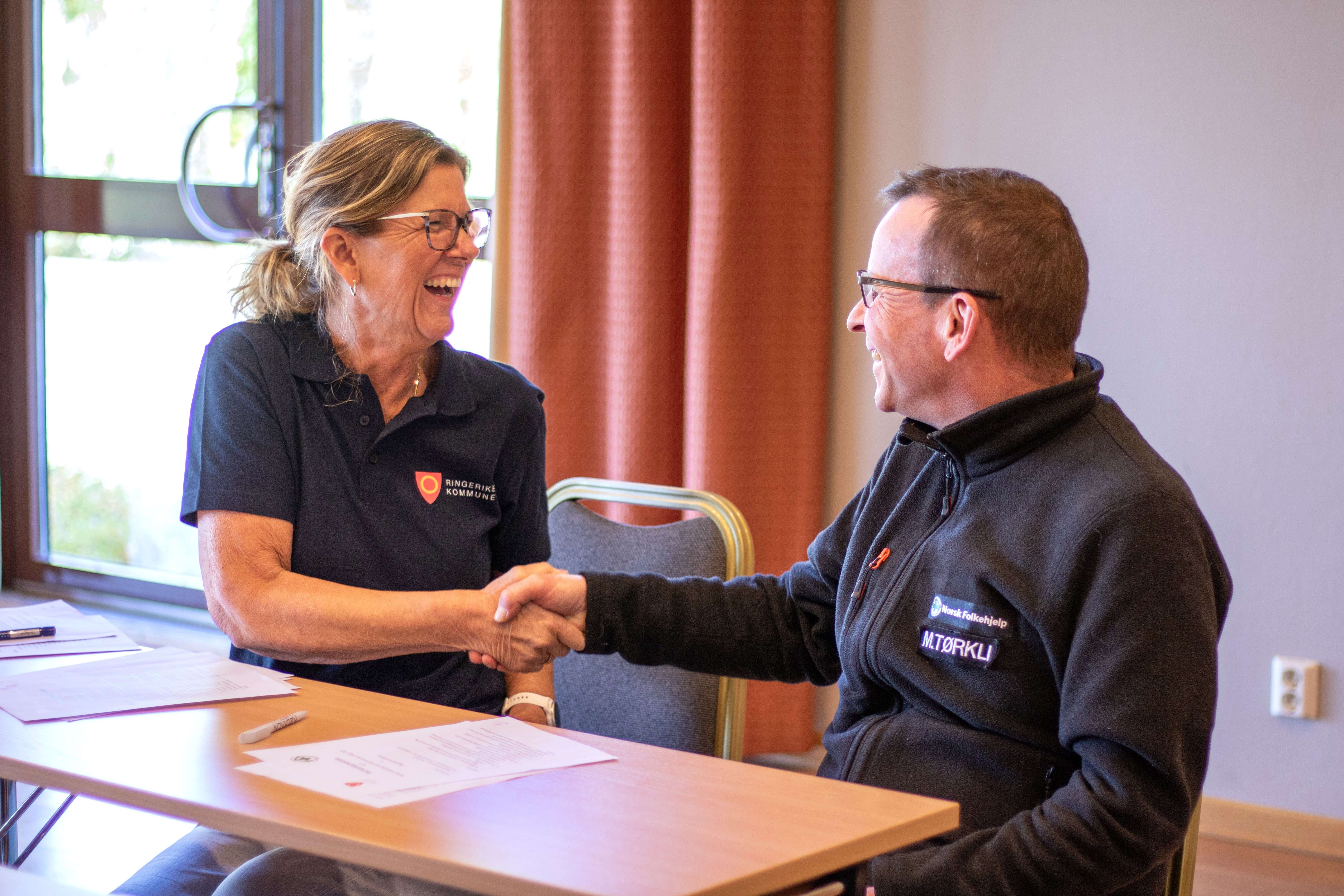 Bildet viser to personer som tar hverandre i hånda og bekrefter avtalen.
