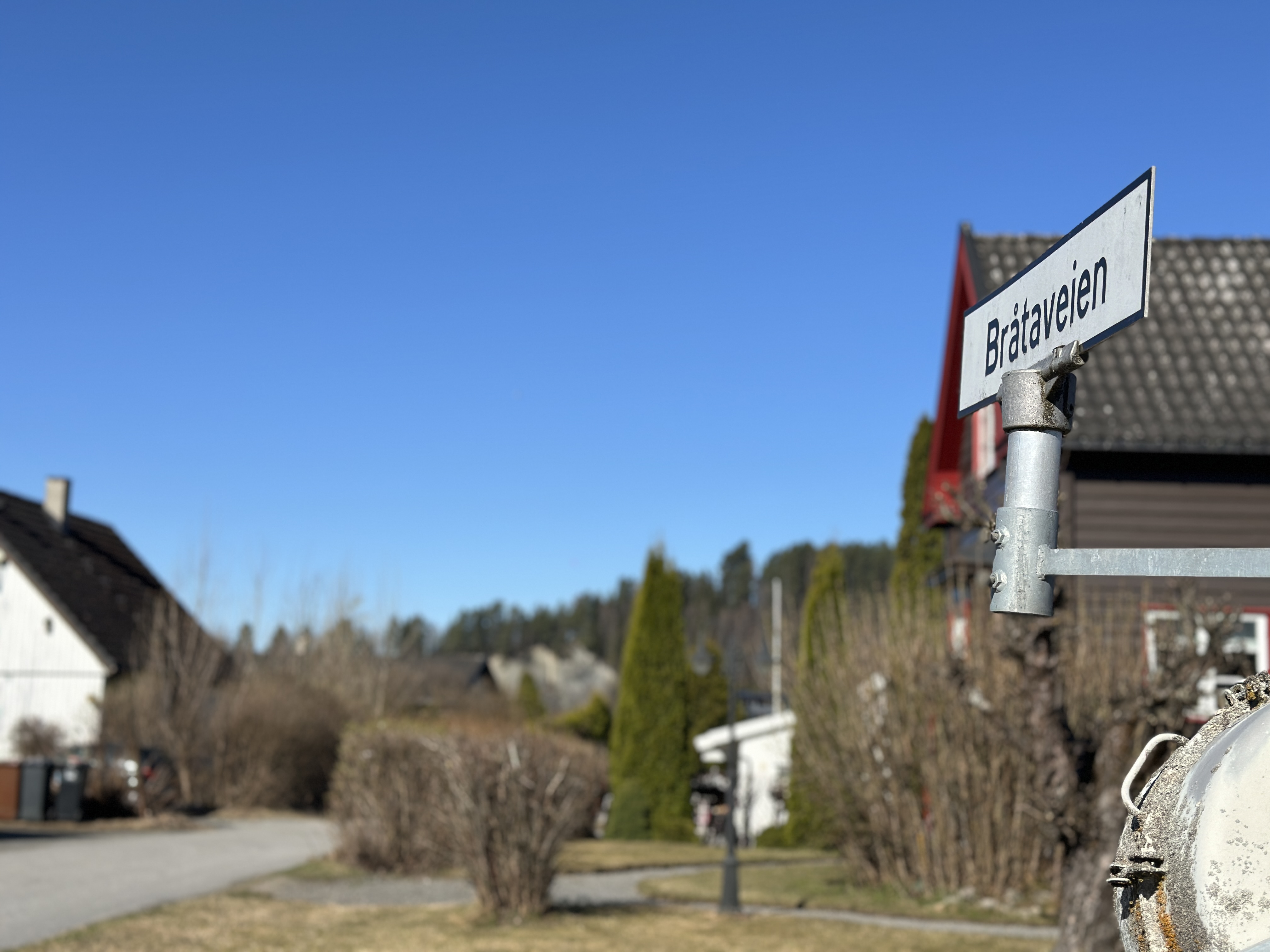 Bildet viser et gateskilt og noen hus i bakgrunnen