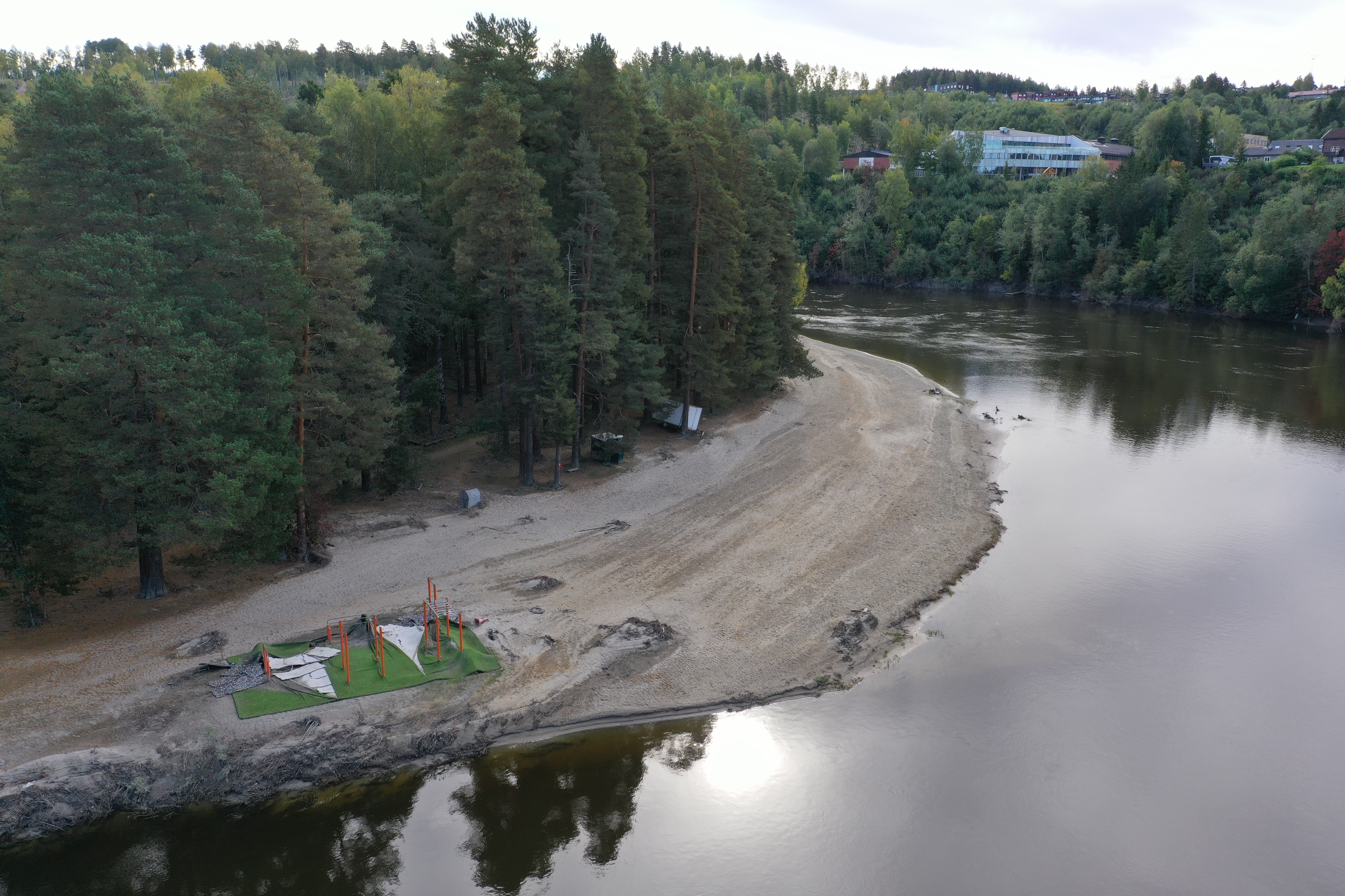 Bildet viser Bystranda med treningsapparatene etter flommens herjinger. Dronefoto.